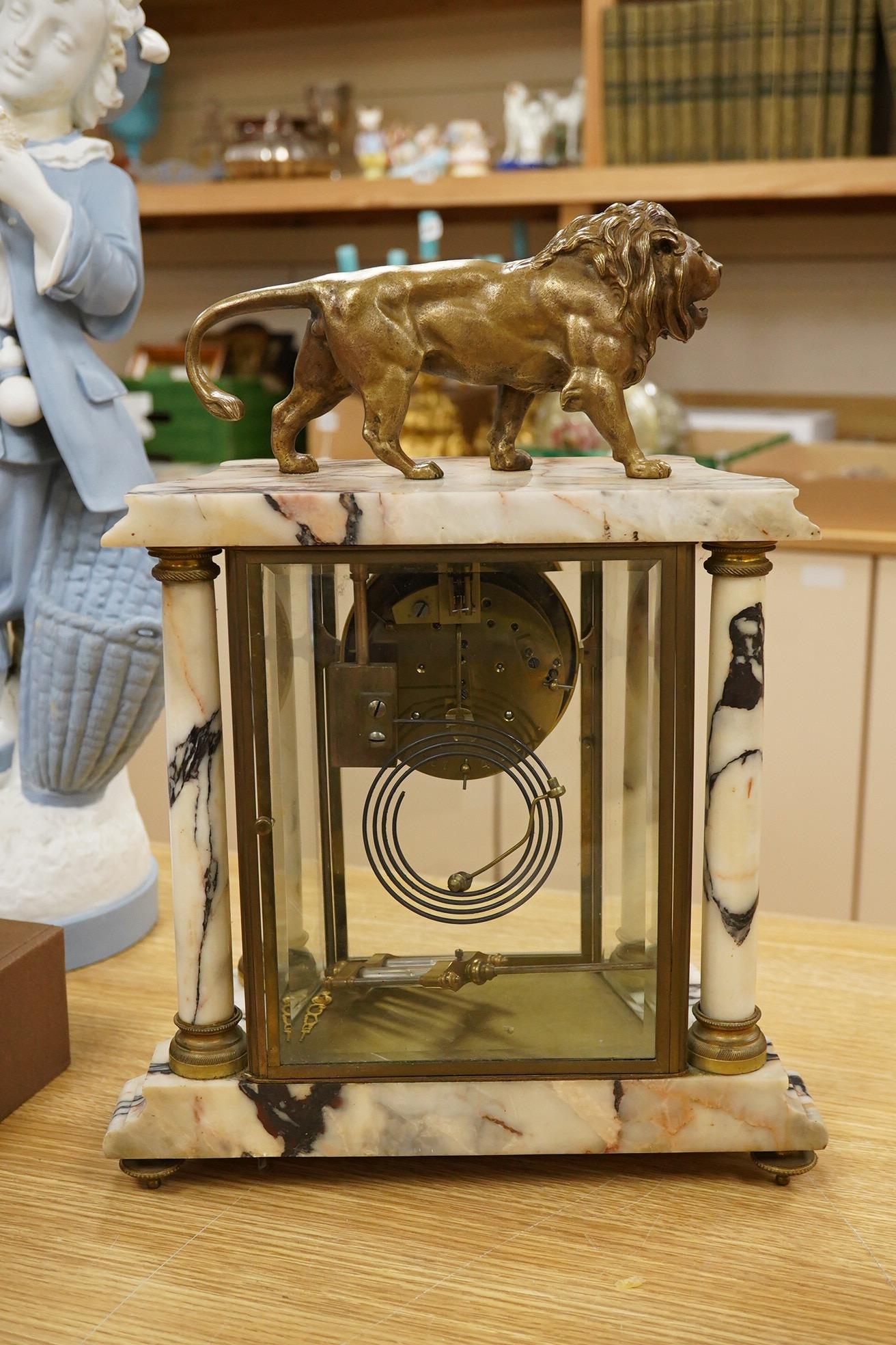 An early 20th century marble mantel clock with lion surmount, with pendulum, 39cm high